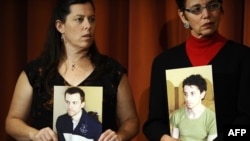 The mothers of Americans Josh Fattal and Shane Bauer and Laura Fattal (left to right) hold their sons' photos at a September press conference in New York.