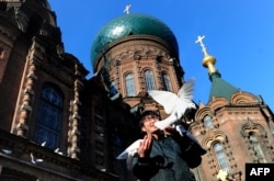 A man stands outside Harbin's St. Sophia Cathedral, a large Orthodox church that reflects the Chinese city's unique history with Russia.