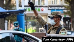 A traffic policeman checks the ID of a driver at a checkpoint amid the coronavirus pandemic in Tashkent. (file photo)