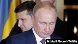 Ukrainian President Volodymyr Zelenskiy stands behind Russian President Vladimir Putin after they met face-to-face for the first time at talks in Paris on December 9 aimed at ending the conflict in eastern Ukraine.