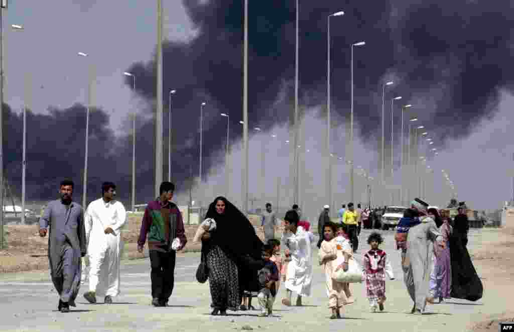 Residents flee the southern city of Al-Basrah, still held by the Iraqi military on March 28.