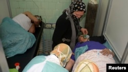 People injured in what the government said was a chemical-weapons attack breathe through oxygen masks as they are treated at a hospital in the city of Aleppo in March.