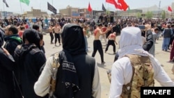 Taliban fighters stand guard as Shi'ite Muslims attend a mourning procession during Ashura in Kabul on August 19, 2021.