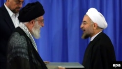 Iranian Supreme Leader Ayatollah Ali Khamenei (left) gives an endorsement letter to newly elected President Hassan Rohani during a ceremony for his confirmation as Iran's president in Tehran on August 3.