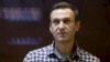 Russian opposition leader Aleksei Navalny stands in a cage in court in Moscow in February.