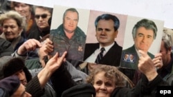 Nationalists hold up pictures of Ratko Mladic, Radovan Karadzic, and Slobodan Milosevic at a rally in 2007. Now they are rallying for Libya's Muammar Qaddafi.