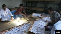 Afghan electoral workers begin counting ballot papers at the end of voting in Kabul on August 20.