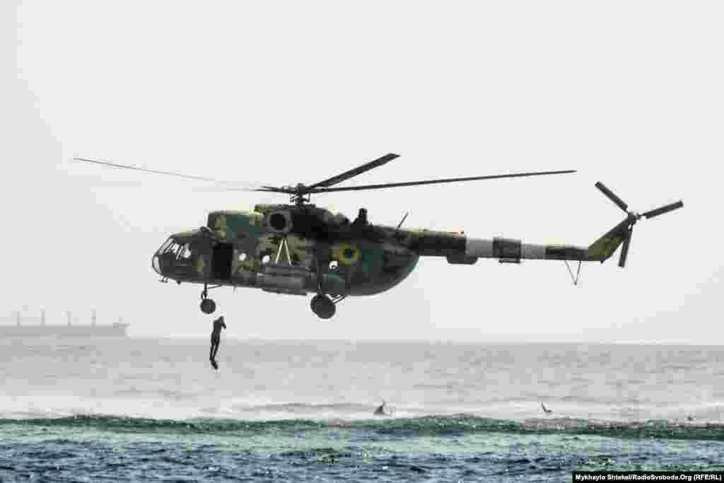 A Ukrainian soldier jumps from a military helicopter during the festivities in Odesa.