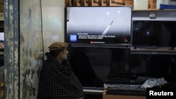 A man in Peshawar, Pakistan, watches news in a shop after the Foreign Ministry announced the country had conducted air strikes inside Iran targeting separatist militants on January 18.