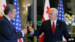 Georgian Prime Minister Giorgi Kvirikashvili (left) raises a toast with U.S. Vice President Mike Pence during an official dinner in Tbilisi on July 31.