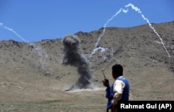 A worker for the HALO Trust watches shrapnel streak into the sky after a controlled detonation of landmines in Afghanistan in 2017. Photo by Rahmat Gul/AP