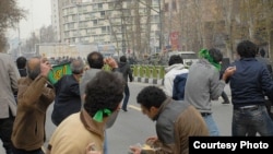 Iranian protesters throw rocks at riot police in Tehran on December 27 (photo: Sara).