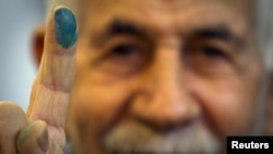 A man shows the ink stain on his finger to prove he voted in the parliamentary elections in a mosque in southern Tehran on March 2.