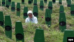 A Muslim woman visits the grave of her brother next to the graves of other victims of the killings by Serb forces in Srebrenica in 1995.