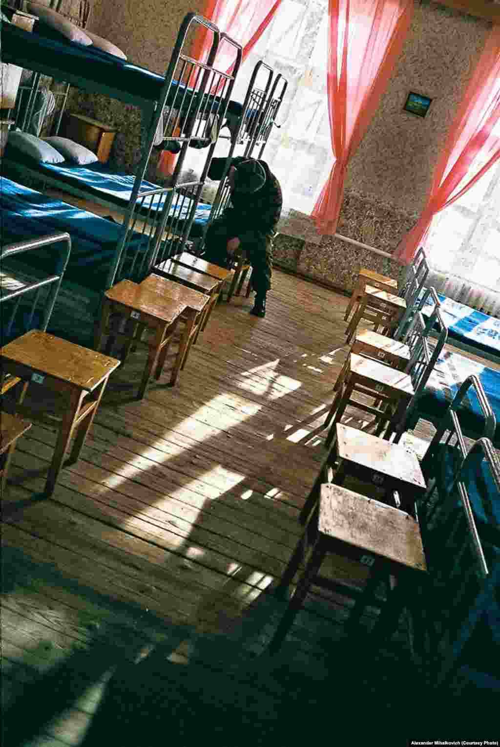 An exhausted soldier falls asleep in his chair. 