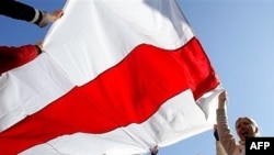 Protesters wave the old national flag in Minsk.