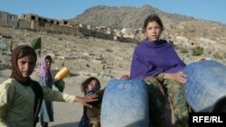 Children carry drinking water by donkey in Kabul.