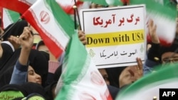 Schoolgirls wave national flags at a rally to mark the 30th anniversary of the Islamic Revolution in Tehran.