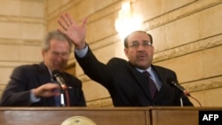 Iraqi Prime Minister Nuri al-Maliki tries to block one of the shoes from hitting U.S. President George W. Bush.