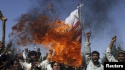 Villagers burn a U.S. flag during a protest against NATO raids in Surkhrod district, Nangarhar Province.