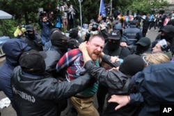 Police try to detain a demonstrator near the parliament building during an opposition protest against "the Russian law" in the center of Tbilisi on May 13.