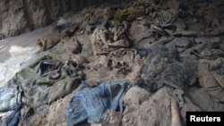 Human skeletons and items of clothing are seen in a mass grave uncovered in northern Balkh Province in January. Construction workers digging a car park found at least 10 human skulls.