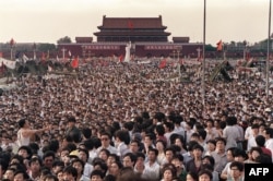 Chinese people gather around a replica of the Statue of Liberty on Tiananmen Square demanding democracy despite martial law in Beijing in June 1989.