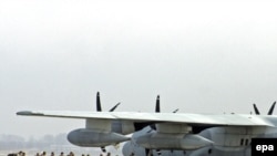 U.S. military servicemen board a plane at the military air base in Manas.