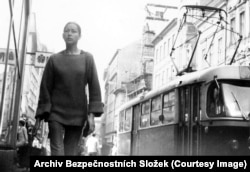 A young woman, lost in thought, strolling through downtown Prague.