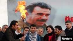 An image of militant Kurdish leader Abdullah Ocalan provides the backdrop for pro-Kurdish activists lighting a Norouz fire in Istanbul on March 17.