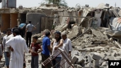 Iraqis stand amid the rubble of destroyed houses following a series of Al-Qaeda bomb attacks in the town of Taji, north of Baghdad which killed at least 42 people last month.