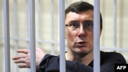 Former Ukrainian Interior Minister Yuriy Lutsenko gestures from a caged area inside the court during a verdict hearing in Kyiv in February.