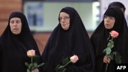 Laura Fattal (right), Nora Shourd (center), and Cindy Hickey hold roses upon their arrival in Tehran.