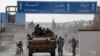 Turkey-backed Syrian rebel fighters sit on a military truck at the border town of Tel Abyad on October 14.