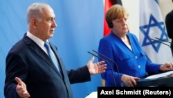 Israeli Prime Minister Benjamin Netanyahu (left) gestures during a news conference with German Chancellor Angela Merkel in Berlin on June 4.