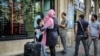 Iranian travelers stand in front of a currency exchange in Tehran, hoping to exchange money on April 11.