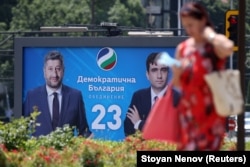 A woman walks past an election billboard for the Democratic Bulgaria party in Sofia.