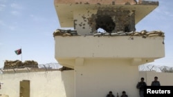 Afghan policemen at a checkpoint tower where a man shot and killed three British soldiers in Helmand Province in July.