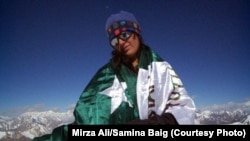 Mountaineer Samina Baig poses with a Pakistani flag during a previous climb.