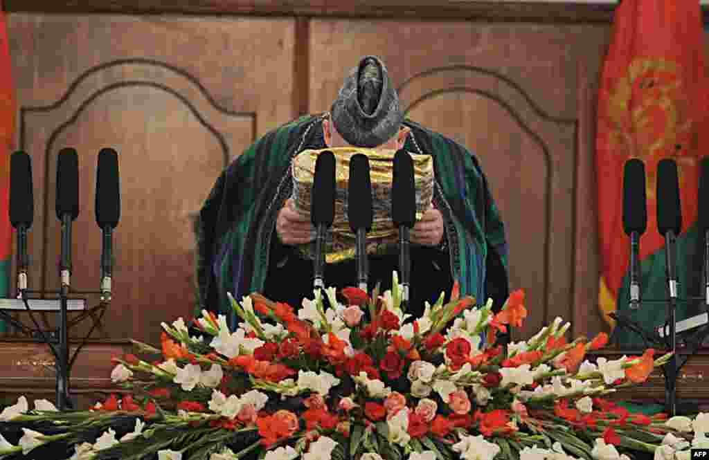 Karzai kisses a large copy of the Koran during his swearing-in&nbsp;as&nbsp;the&nbsp;country&#39;s&nbsp;president for another five years at the Presidential Palace in Kabul on November 19, 2009. A runoff vote with rival Abdullah Abdullah was canceled after Abdullah refused to participate, citing massive election fraud. 