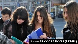 Representatives of Transparency International distribute copies of the corruption report to students in Tbilisi as part of Anticorruption Day activities.