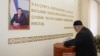 A man casts his ballot next to a portrait of Uzbek President Shavkat Mirziyoev during parliamentary elections in Tashkent in December 2019.