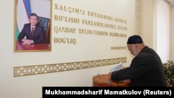 A man casts his ballot next to a portrait of Uzbek President Shavkat Mirziyoev during parliamentary elections in Tashkent in December 2019.