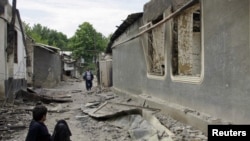 Ethnic Uzbeks on a street in the village of Vlksm, destroyed during recent clashes in Kyrgyzstan.