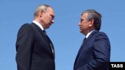 Russian President Vladimir Putin (left) speaks with interim Uzbek President Shavkat Mirziyaev after laying flowers at the grave of late Uzbek President Islam Karimov on September 6, 2016.