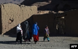 Hazara women walk along a road in Bamiyan Province, where they have more freedom than the Taliban would allow.