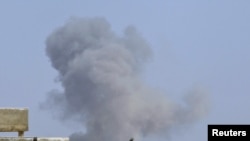 Smoke rises after a NATO and coalition air strike in Tripoli on April 14.