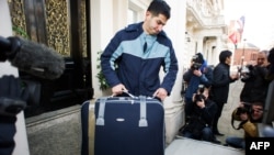 A removals worker carries a suitcase out of a residential annex of the Iranian Embassy in central London on December 2.