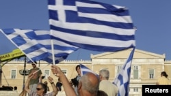 A man holds a Greek flag before a conservative New Democracy party rally on Syntagma Square in Athens on June 15. 