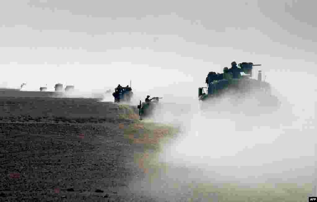 U.S. Marines cross from Kuwait into Iraq as they prepare to capture the key Iraqi city of Al-Basrah. 